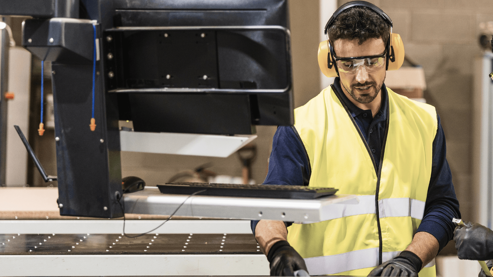 İş güvenliği ekipmanları kullanan CNC tezgah operatörü tarafından üretim paneli üzerinden veri girişi yapılması